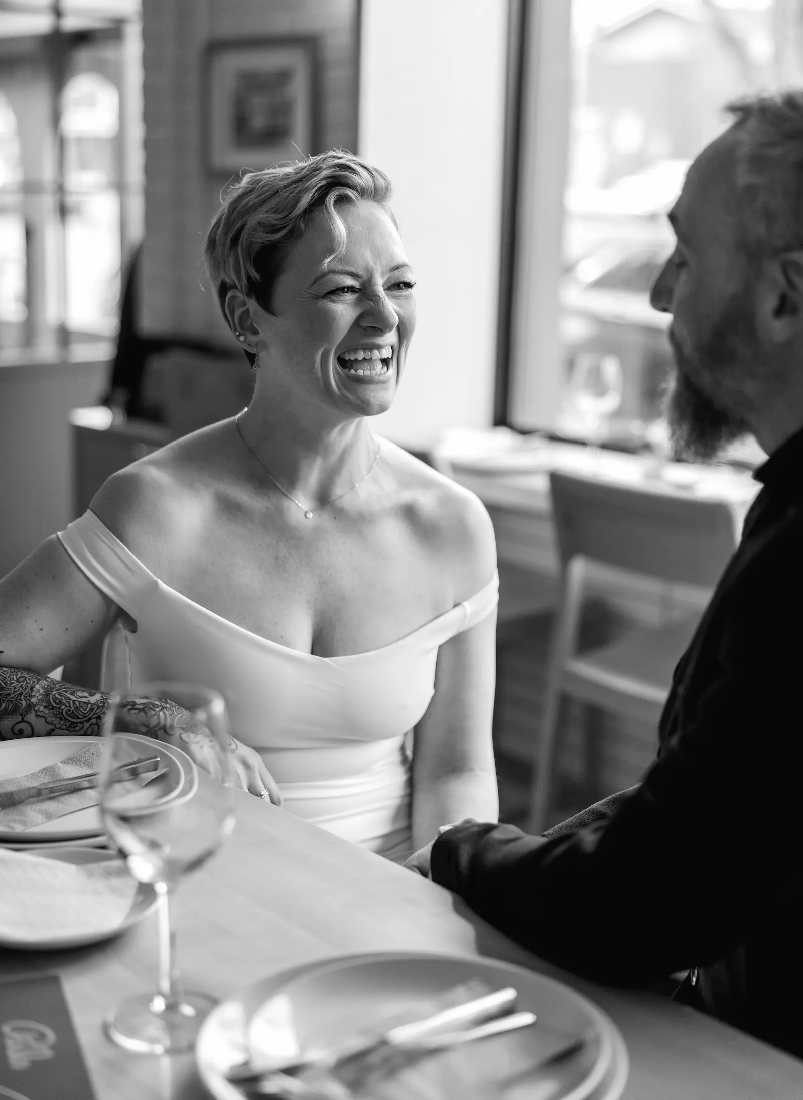 bride looking at her husband in and smiling big at pals sandwich shop for a small intimate wedding reception