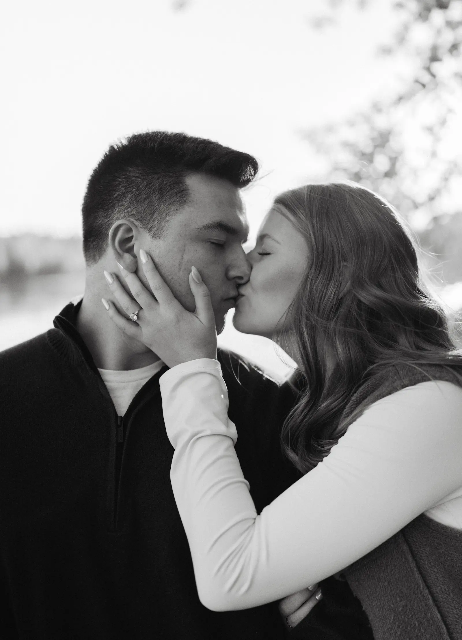 close up of couple kissing with woman's hand on her fiancee's cheek