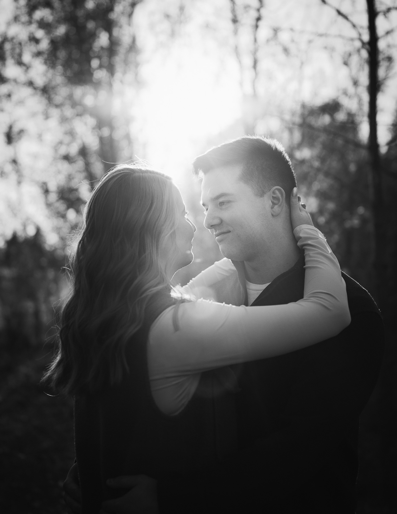 Couple embracing during a fall engagement session at Capilano Park in Edmonton, Alberta.