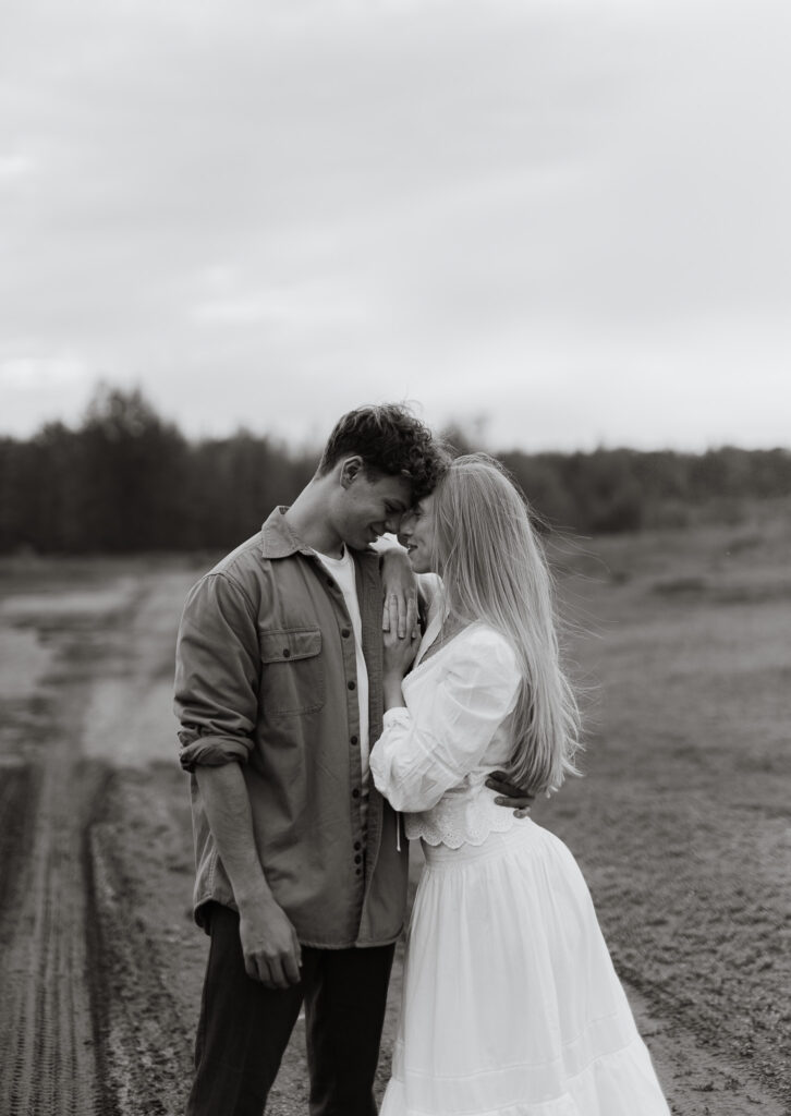 Engaged couple sharing a quiet moment together during an engagement session at Terwillegar Dog Park in Edmonton, Alberta.