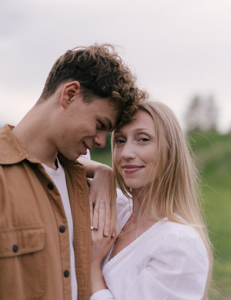 Close-up portrait of an engaged couple at Terwillegar Dog Park in Edmonton, with the engagement ring visible on the bride-to-be's hand.
